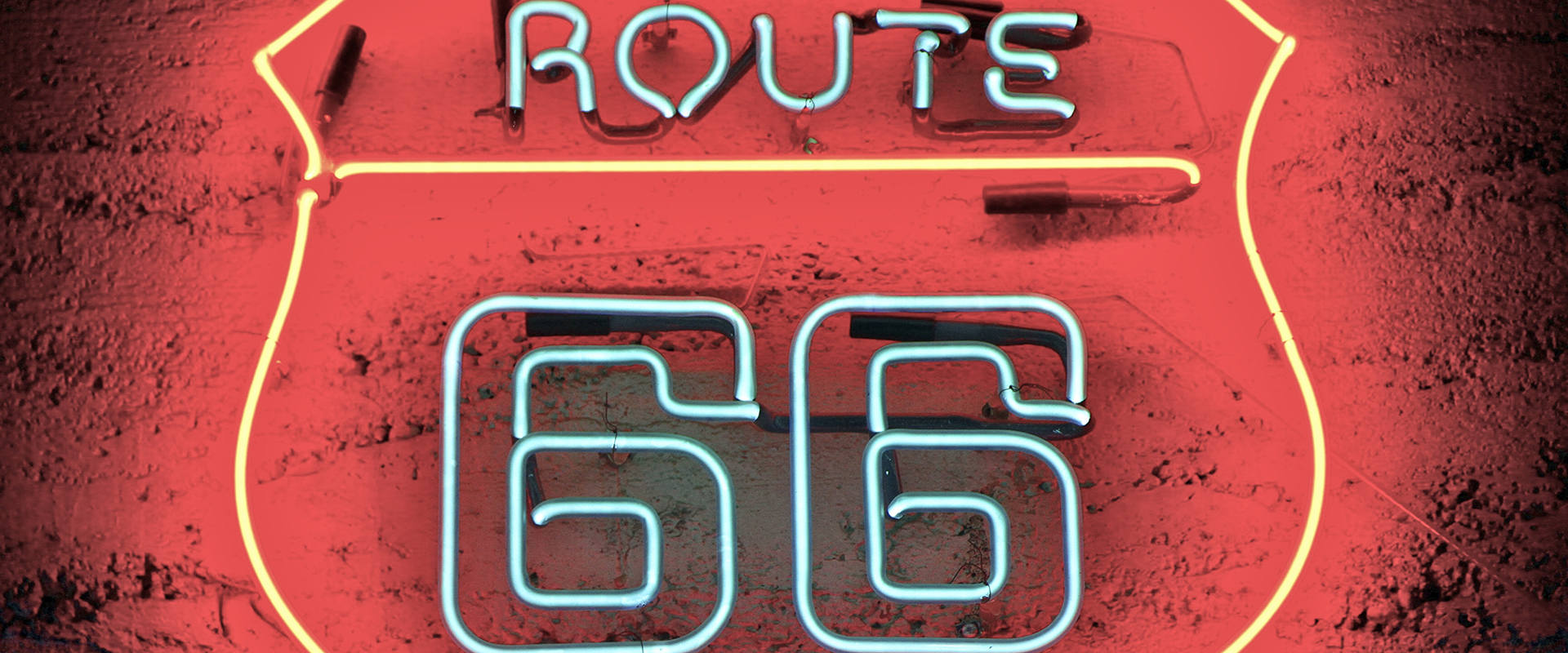 Route 66 neon light on red brick wall